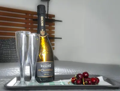 a bottle of wine and glasses on a table with cherries at B&Baldo Vatican in Rome