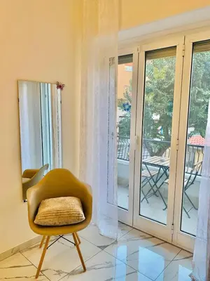 a yellow chair in a room with sliding glass doors at B&Baldo Vatican in Rome