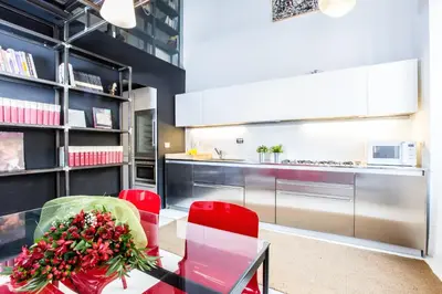 a kitchen with red chairs and a glass table at Trastevere Design Loft - My Extra Home in Rome