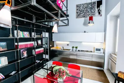 a kitchen with red chairs and a glass table at Trastevere Design Loft - My Extra Home in Rome