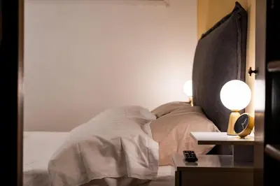 a bedroom with a bed with two lamps on a table at SKY DOMUS ROME Historic Center Penthouse With Jacuzzi in Rome