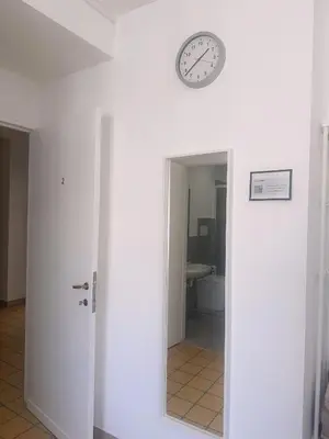 a clock on a wall above a door with a bathroom at Lisa HOUSE in Rome