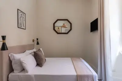 a bedroom with a bed and a mirror on the wall at Casa Enea - Pretty Homes in Rome