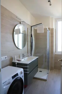 a bathroom with a shower and a sink and a washing machine at Vatican Jacuzzi House in Rome