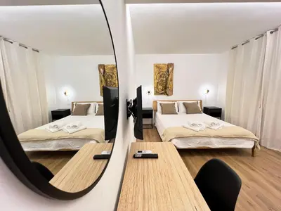 a hotel room with two beds and a mirror at EppyTime Roma in Rome
