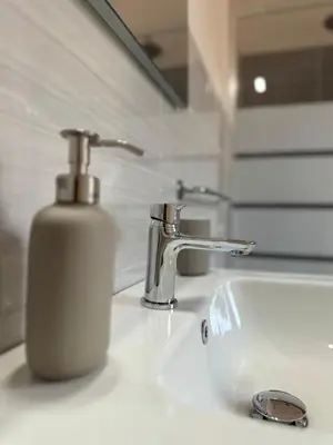 a soap dispenser sitting on top of a bathroom sink at Alloggio turistico Gloria in Rome