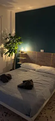 a bedroom with a large bed with a green wall at Alloggio turistico Gloria in Rome