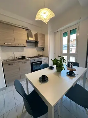 a kitchen with a white table and blue chairs at Alloggio turistico Gloria in Rome