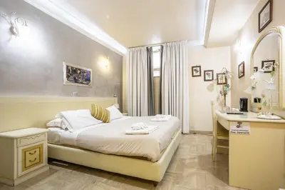 a bedroom with a bed and a desk and a sink at Opera Theater Relais in Rome