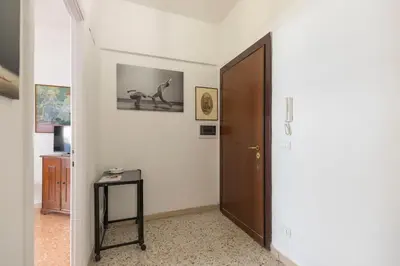 a hallway with a door and a stool and a table at Casa Lilly, appartamento luminosissimo a Roma in Rome