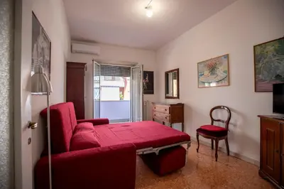 a living room with a red couch and a chair at Casa Lilly, appartamento luminosissimo a Roma in Rome