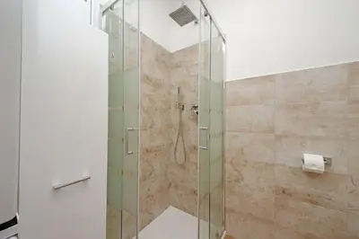 a bathroom with a shower with a glass door at Prestigious Re di Roma Apartment in Rome