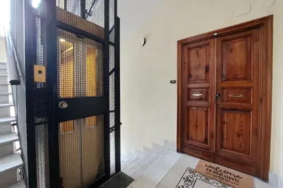a wooden door with a gate next to a staircase at Prestigious Re di Roma Apartment in Rome