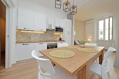 a kitchen and dining room with a wooden table and chairs at Prestigious Re di Roma Apartment in Rome