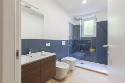 a bathroom with a sink and a toilet and a tub at Hostly-Libia Light Lodge-10min Metro to Colosseum in Rome