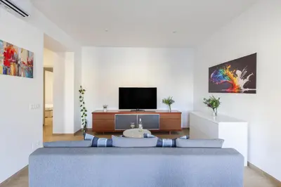a living room with a couch and a tv at Hostly-Libia Light Lodge-10min Metro to Colosseum in Rome