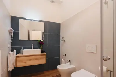a bathroom with a sink and a toilet and a mirror at PAX apartment in Rome
