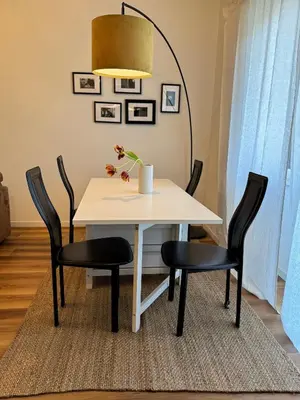 a white table with four chairs and a lamp at Appartamento con vista Vaticano in Rome