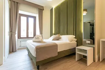 a bedroom with a bed and a window and a mirror at Flat 285 La Suite in Rome