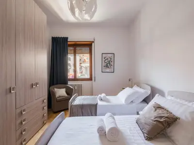 a bedroom with two beds and a chair at The Best Rent - Spacious flat a stone's throw from the Vatican in Rome