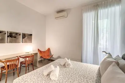 a white room with a bed and a table and chairs at Via Provana San Giovanni 2 bedroom apartment in Rome