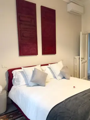 a bedroom with a white bed with two pictures on the wall at Trastevere 40 in Rome