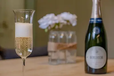 a glass of champagne next to a bottle of wine at Glorioso Apartment Trastevere in Rome