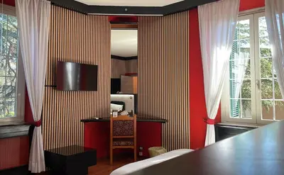 a bedroom with red and white striped walls and a table at La Villa di Roma in Rome