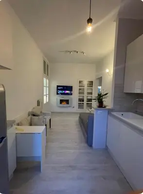 a kitchen and living room with a couch and a tv at Colosseum Lindarella Home in Rome