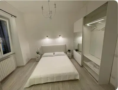 a white bedroom with a large bed and a mirror at Colosseum Lindarella Home in Rome