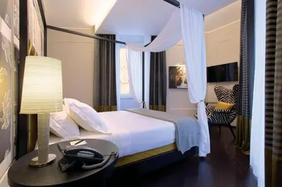 a bedroom with a bed and a desk with a lamp at Stendhal Luxury Suites in Rome