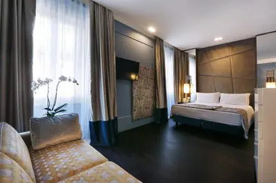 a hotel room with a bed and a couch at Stendhal Luxury Suites in Rome