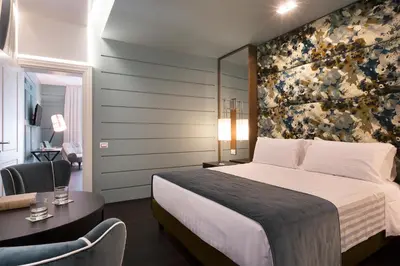a hotel room with a bed and a desk and chair at Stendhal Luxury Suites in Rome