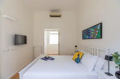 a white bedroom with a bed and a tv at iFlat Vatican Elegant and Spacious Apartment in Rome