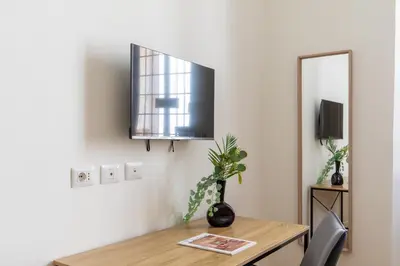 a dining room table with a mirror and a tv at iFlat Vatican Elegant and Spacious Apartment in Rome