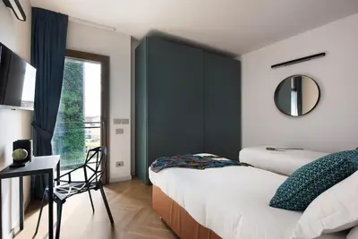 a bedroom with two beds and a desk and a window at Idyllia - Maia luxury apartment in Rome