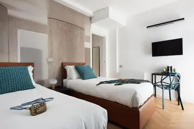 a bedroom with two beds and a flat screen tv at Idyllia - Maia luxury apartment in Rome