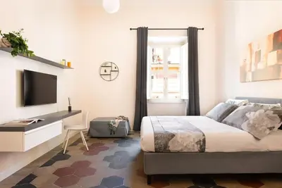 a bedroom with a bed and a flat screen tv at Idyllia - Vatican Stylish Flat in Rome