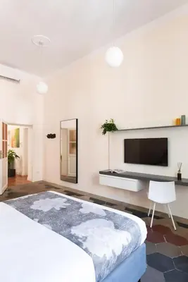a white bedroom with a large bed and a flat screen tv at Idyllia - Vatican Stylish Flat in Rome