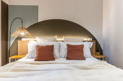 a large white bed with two brown pillows on it at Dafne room Nido perfetto per coppie a Roma in Rome