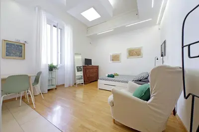 a white living room with a couch and a table at Delizioso loft all'Esquilino in Rome