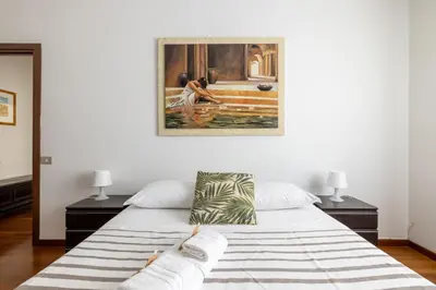 a bedroom with a bed with a painting on the wall at Aurelia Dream with Terrace in Rome