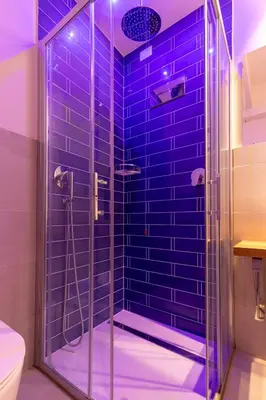 a bathroom with a shower with blue tiles at Dafne room Speciale, elegante con balcone in Rome