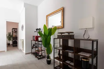 a living room with a mirror and a plant at Ginny in Trastevere in Rome