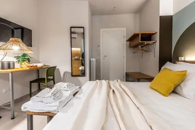 a bedroom with a large white bed and a desk at Dafne room Un'oasi romana per coppie in Rome