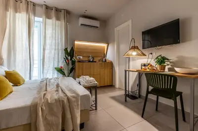 a bedroom with a bed and a table and a desk at Dafne room Un'oasi romana per coppie in Rome