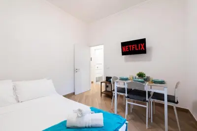 a bedroom with a bed and a table and a dining room at Alba Vatican Apartment in Rome