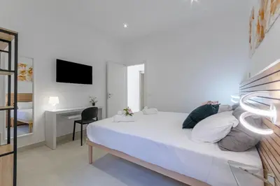 a white bedroom with a bed and a desk at Roma apartment near to Colosseum Re-House in Rome