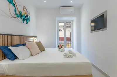 a bedroom with a large white bed with stuffed animals on it at Roma apartment near to Colosseum Re-House in Rome