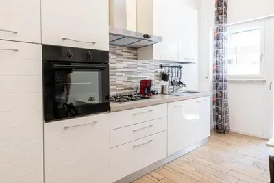a kitchen with white cabinets and a stove top oven at Rea house Colli Albani - B&Brother's rome in Rome